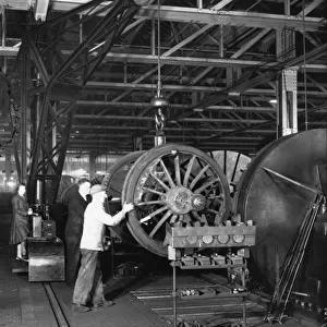 Swindon Works employees manouvering a wheel set by crane, c. 1940