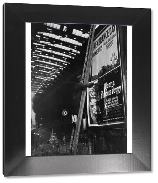 Woman pasting a billboard poster at Paddington station, 1943