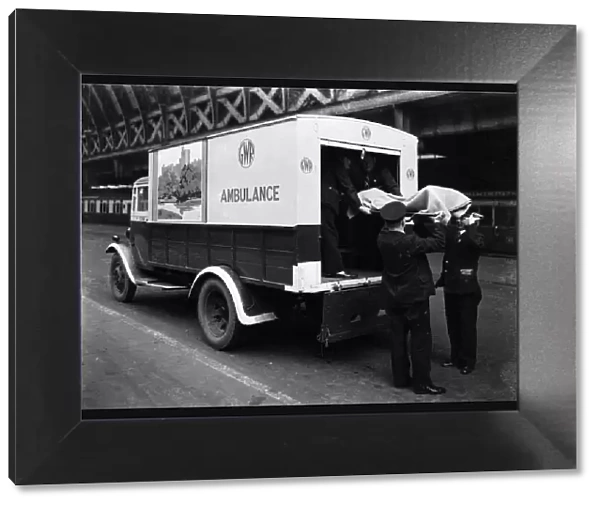 GWR staff loading a stretcher into a parcel van which has been converted into an ambulance, 1940
