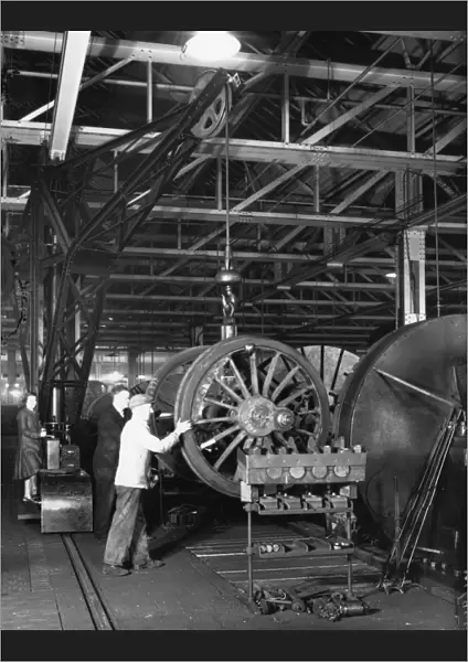 Swindon Works employees manouvering a wheel set by crane, c. 1940