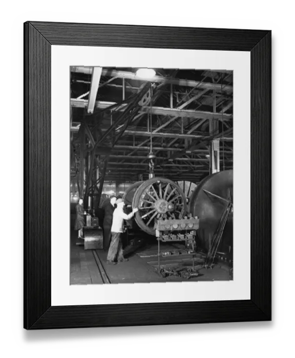 Framed Print : Swindon Works employees manouvering a wheel set by crane, c. 1940