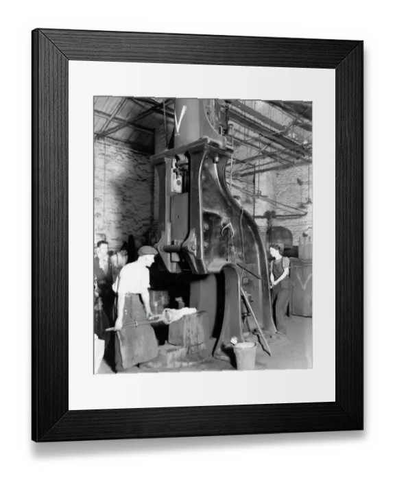 Framed Print : A man and woman carrying out work on a steam hammer during WW2, 1942