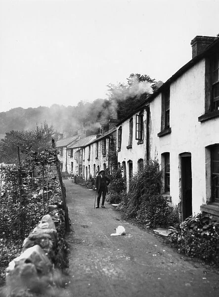 Lydbrook, c.1925. A man and his dog stand outside a row of pretty white