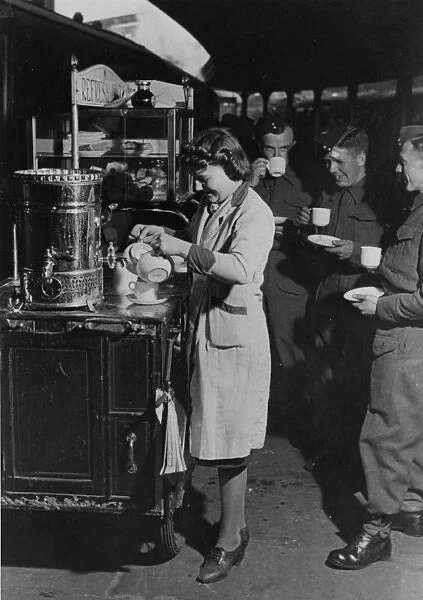Servicemen drinking tea from a refreshment trolley on Paddington station, during WWII
