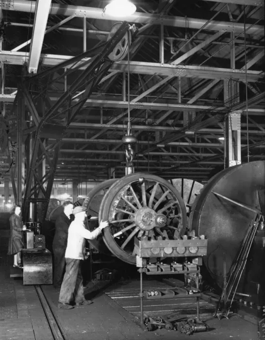 Framed Print : Swindon Works employees manouvering a wheel set by crane, c. 1940