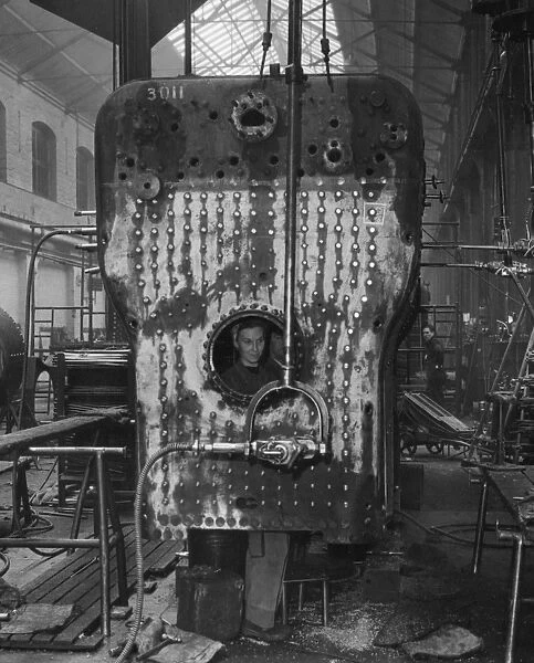 V Shop, 1951. Female member of staff drilling boiler from inside