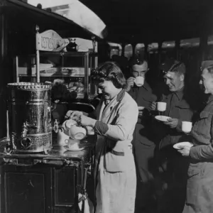 Servicemen drinking tea from a refreshment trolley on Paddington station, during WWII