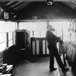 Signalman in operating signal levers during wartime, c. 1940