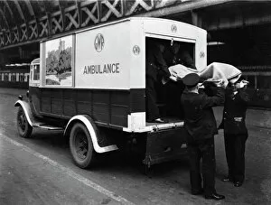 1940 Gallery: GWR staff loading a stretcher into a parcel van which has been converted into an ambulance, 1940