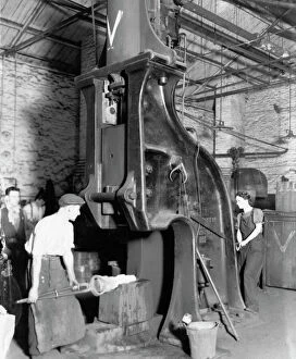 War Workers Gallery: A man and woman carrying out work on a steam hammer during WW2, 1942