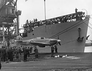 Cardiff Docks Collection: A Sea Hurricane being loaded onto an armed merchant ship at Cardiff docks, c.1941