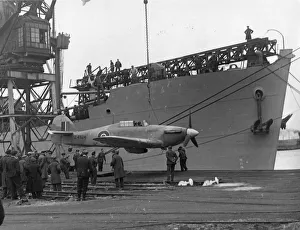 The Railway at War Collection: A Sea Hurricane being loaded onto an armed merchant ship at Cardiff docks, c.1941
