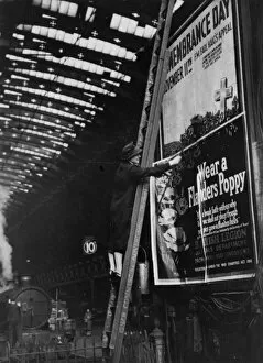 Second World War Gallery: Woman pasting a billboard poster at Paddington station, 1943